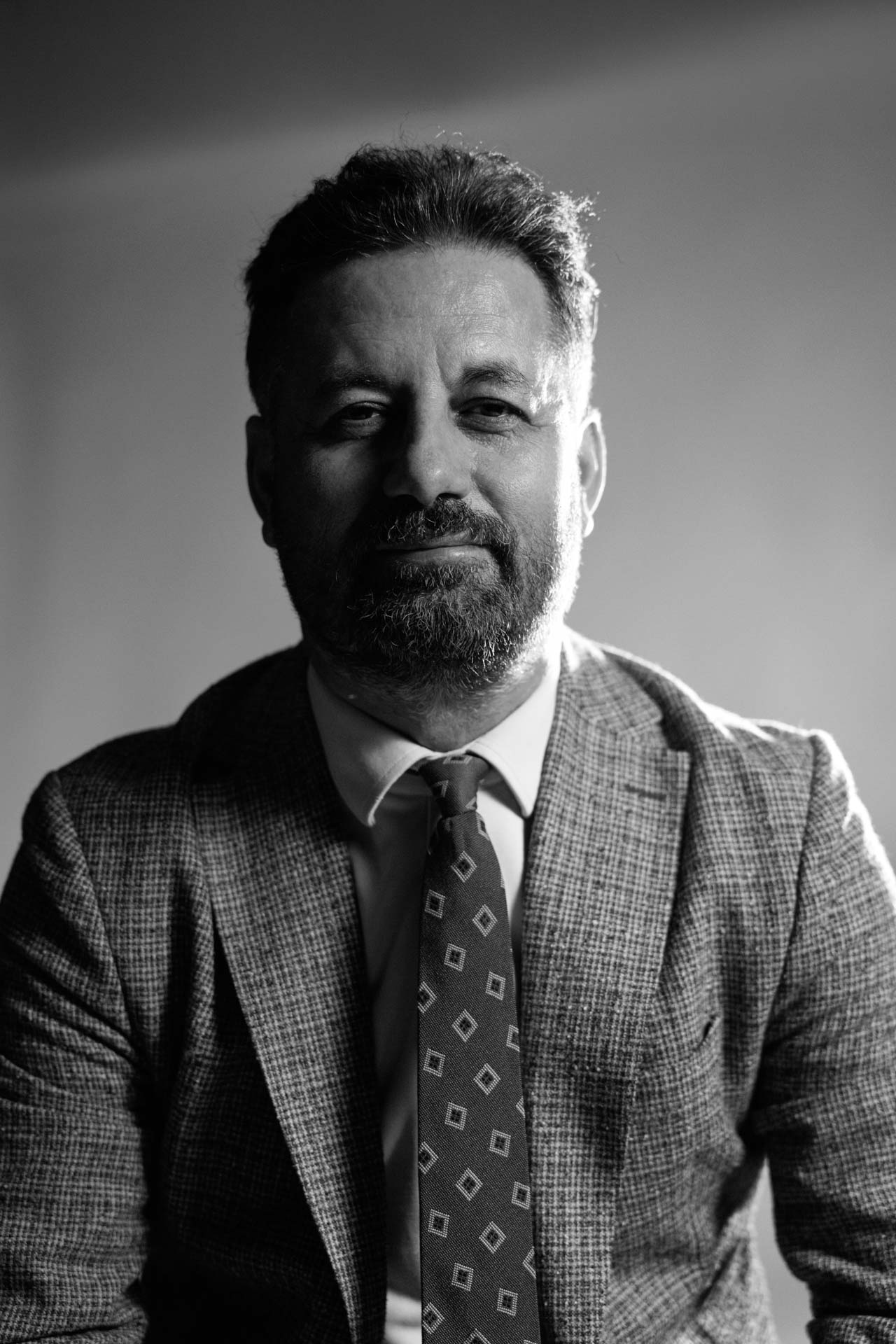 Ankara profesyonel fotoğraf stüdyosunda çekilmiş, dramatik ışık kurgusuna sahip siyah beyaz kurumsal yönetici portresi.
